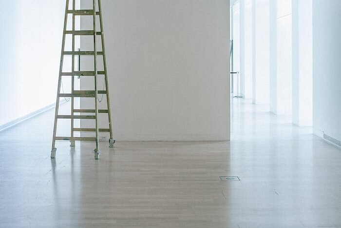 Empty corridor with ladder and lamps on ceiling